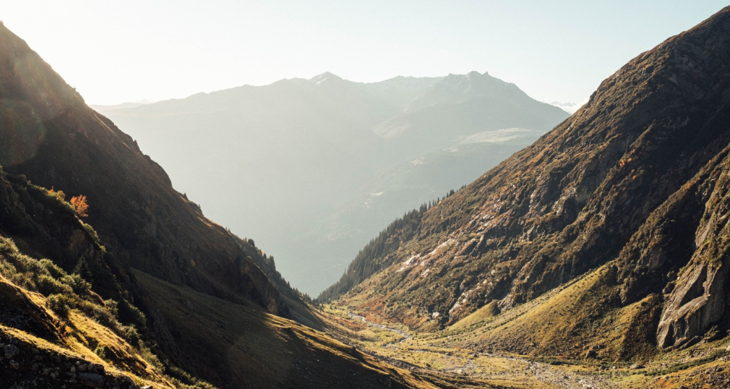 Ein Tal von der Sonne in warmes Licht gebettet.