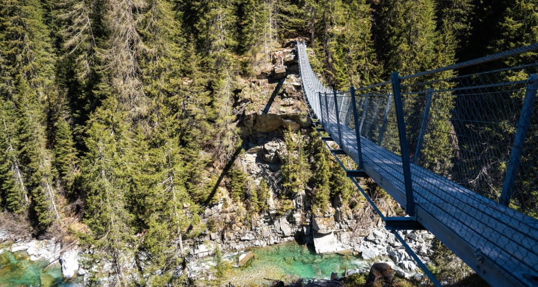 Die Hängebrücke führt hoch über den Averser Rhein