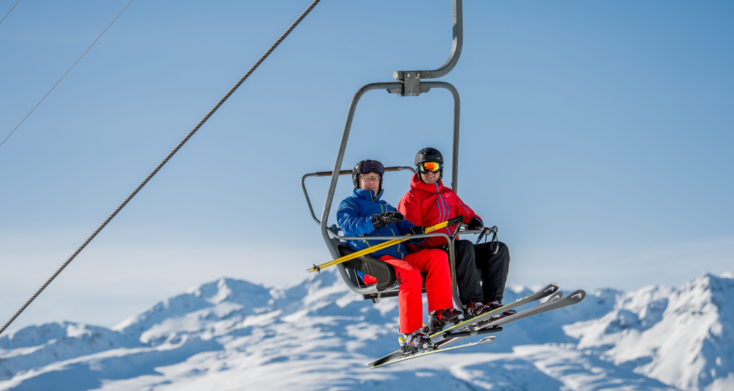 Das Foto zeigt zwei Männer auf der Sesselbahn