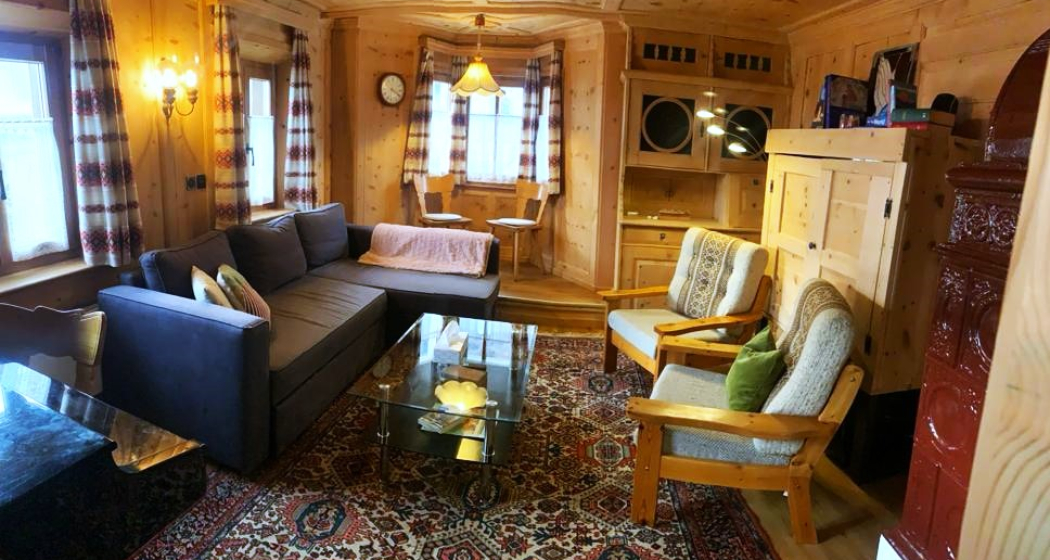 Alte Arvenstube mit Sofa, Sesseln, Büchern und TV Alte Arvenstube mit Sofa, Sesseln, Büchern und TV